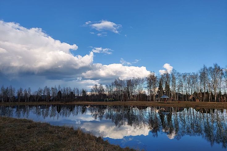 Eine weite Wasserfläche, gespiegelt vom wolkenlosen Himmel darüber. Kaltes Licht. Russland.