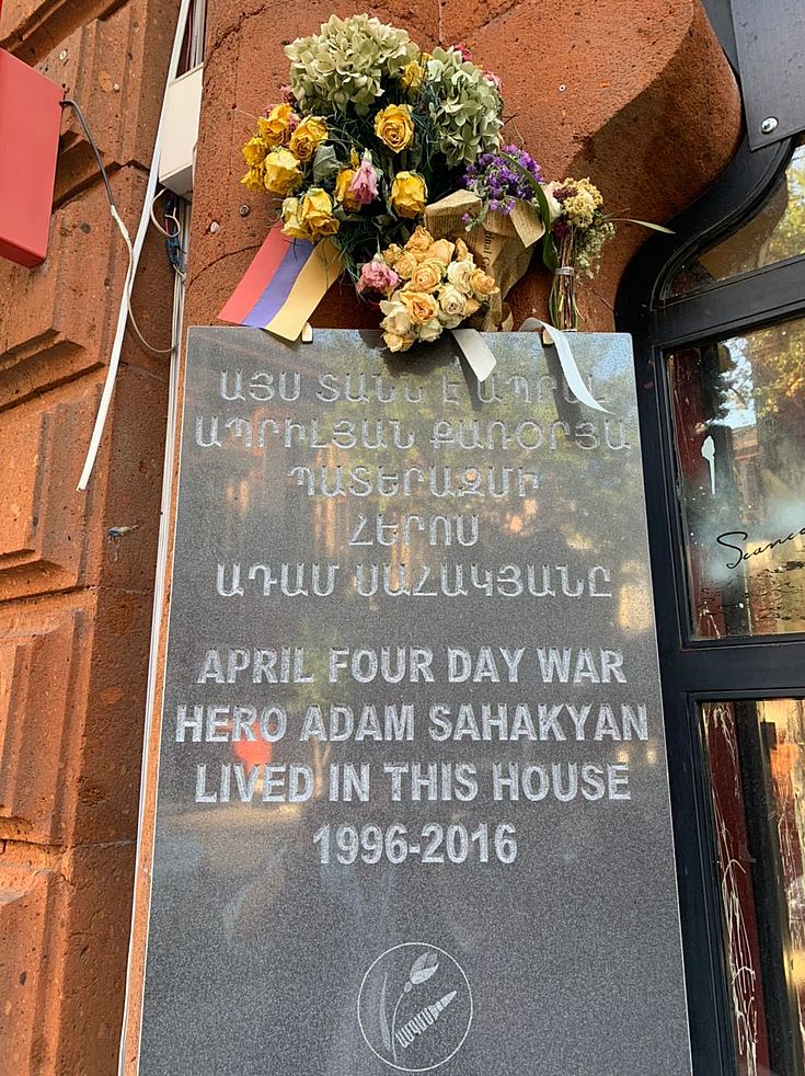 Eine Gedenktafel aus Marmor mit Blumen oben daran