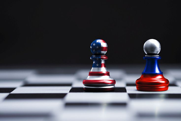 Zwei Schachfiguren, je in den Farben Russlands und der USA