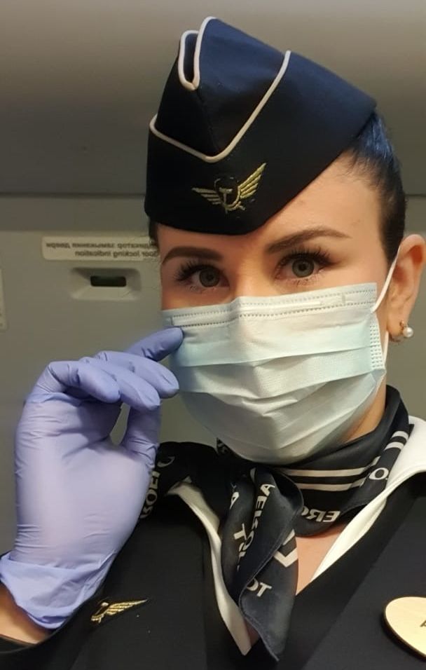 Flugbegleiterin mit Schutzmaske