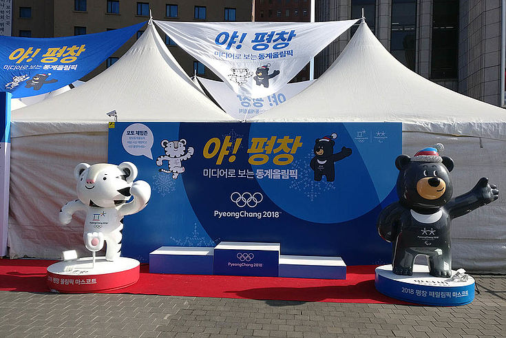 Bär und Tiger als aufblasbare Plastikfiguren "tanzen" vor dem Siegertreppchen