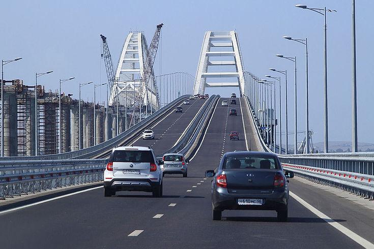 Zwei Autos die auf die Krim-Brücke in Kertsch fahren.