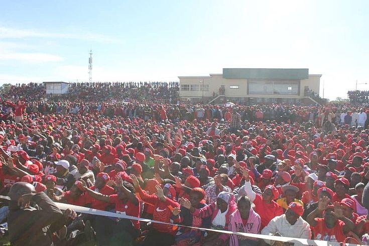 Große Menschenmenge in die selben "roten" T-Shirts  gekleidet. Offenbar Anhänger derselben Partei.