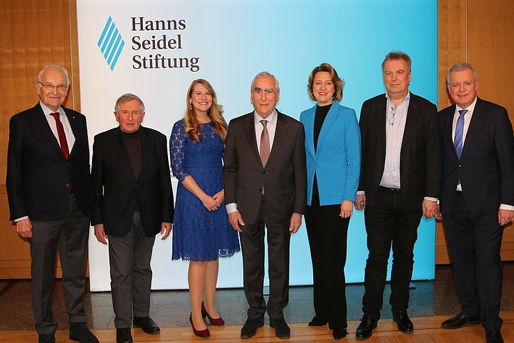 Die Gruppe steht vor einem Aufsteller der Hanns-Seidel-Stiftung.